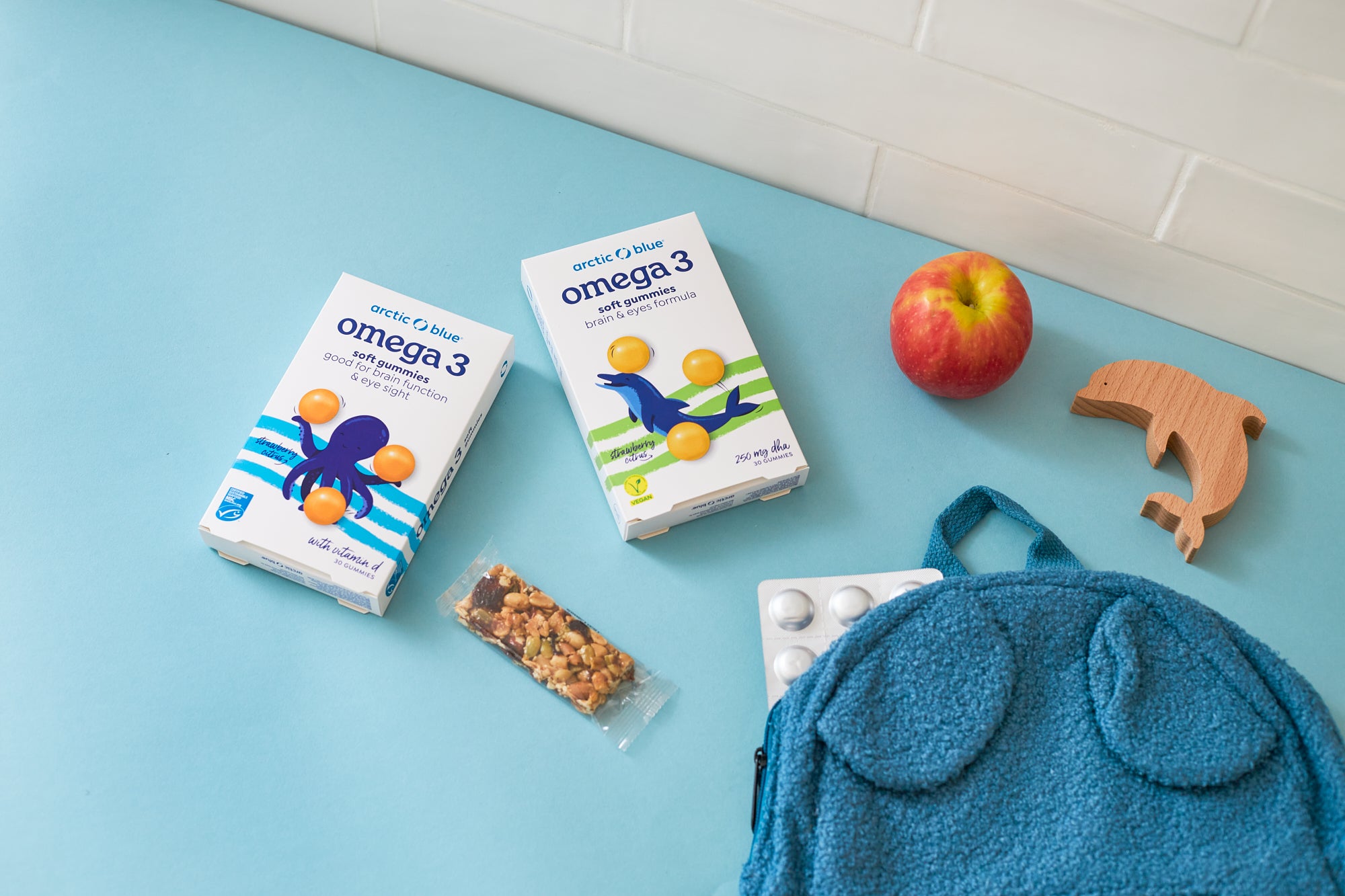 arctic blue gummies on a table with a school bag and an apple