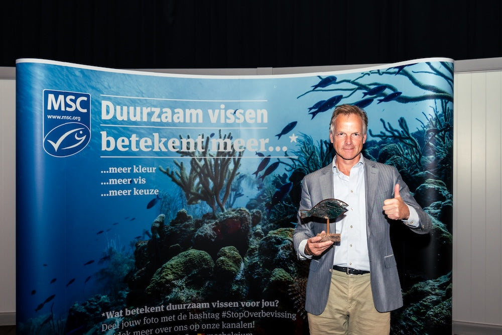 Arctic Blue-oprichter Ludo met een MSC-award voor een banner met de tekst Duurzaam vissen betekent meer