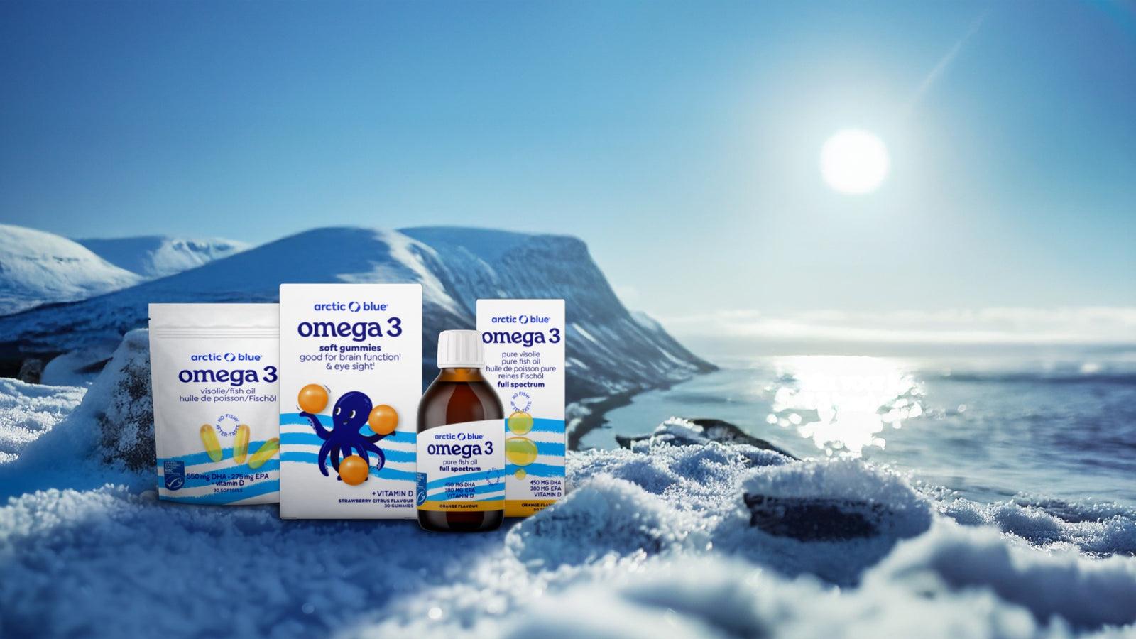 De Arctic Blue omega 3-productlijn met zakje softgels, doosje gummies, fles visolie en doos full spectrum in een besneeuwd arctisch landschap